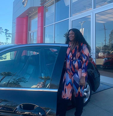 woman standing behind black car door